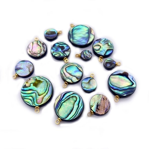 Macro detail of various sizes of natural abalone shell round pendants with gold loops