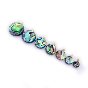 Macro detail of multi-size round abalone shell pendants with golden loops on white background