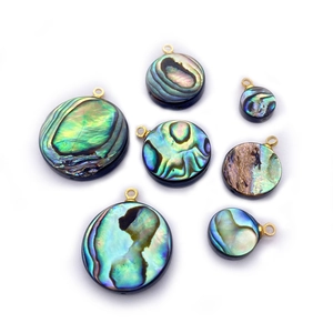 Detailed macro view of mixed size circular abalone shell pendants with gold loops