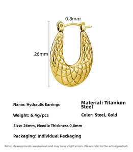 Detail view of U-shaped titanium steel earrings with textured grid pattern in gold finish