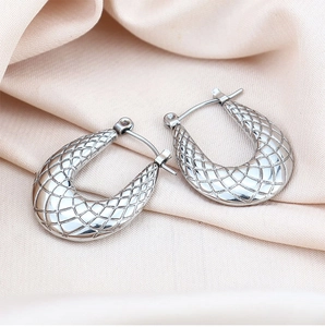 Detail of silver U-shaped earrings with textured grid pattern on satin background