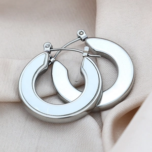 Silver geometric U-shaped titanium earrings on champagne silk background