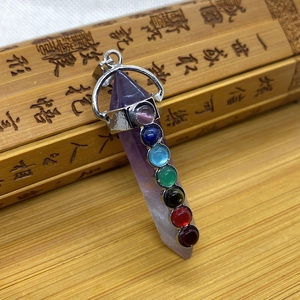 Macro detail of purple amethyst hexagonal prism pendant with seven colorful chakra beads
