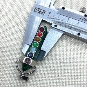 Measuring the 15mm width of a pyramid chakra malachite pendant with a caliper