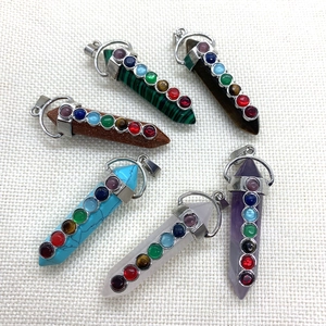 Set of 6 hexagonal crystal prism pendants with seven chakra stones on white fabric
