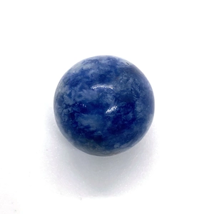 Macro shot of a polished natural blue sodalite round stone bead with white marble texture