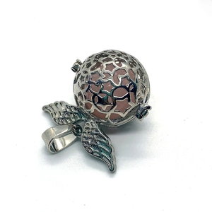 Detailweergave van de zilveren stervormige kooihanger met een roze edelsteenkraal erin