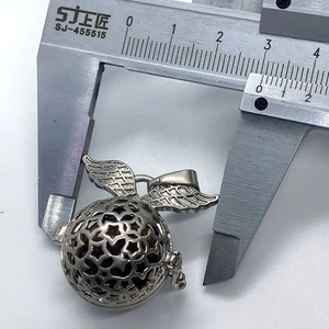 Detailopname van een 25mm zilveren ster-medaillon met vleugels gemeten met een schuifmaat