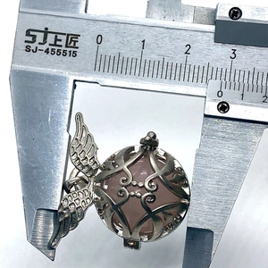 Macro view of measuring tiger eye stone wing pendant size with a digital caliper
