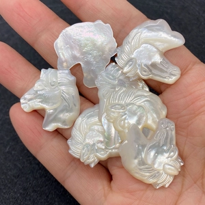 Macro shot of hand-carved white mother of pearl shell horse head beads for jewelry DIY