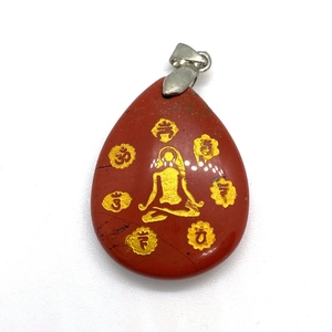 Macro view of red jasper teardrop pendant with gold meditation figure and chakra symbols