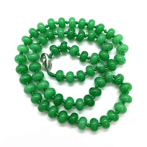 Macro shot of 5x9mm green natural stone rondelle beads with silver lobster clasp detail