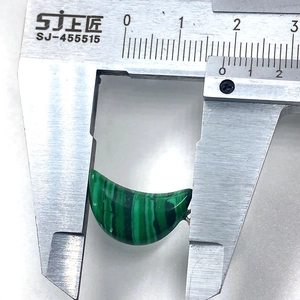 Macro shot showing 16mm width measurement of crescent-shaped green malachite pendant