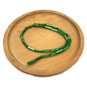 Perline cilindriche in conchiglia verde 4x13mm su vassoio in legno per gioielli