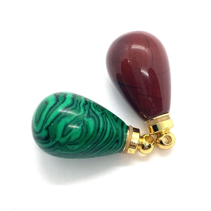 Macro view of teardrop natural stone pendants in malachite green and jasper red textures