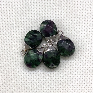 Macro detail of five teardrop ruby in zoisite natural stone charms with silver metal loops