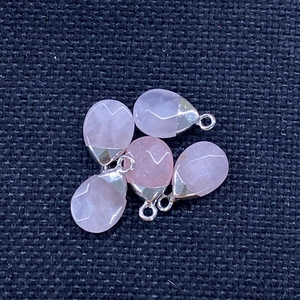Detail view of five teardrop pink quartz stone pendants with silver-colored bails