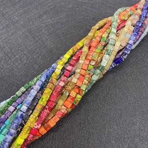 Macro-detail van kubusvormige natuursteen kralen met diverse minerale texturen en kleuren