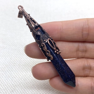 Detailed view of blue goldstone hexagonal pyramid pendant with vintage copper filigree cap