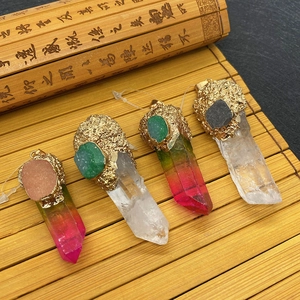 Natural crystal stone pendants with gold lava metal caps on a bamboo mat background