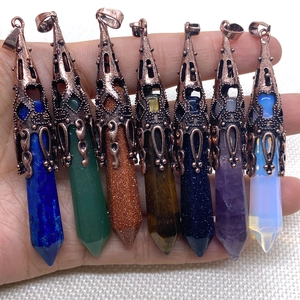 Set of seven hexagonal natural stone pendants with vintage copper caps held in hand