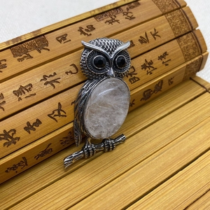 Detalle del colgante de búho con piedra natural y plumas grabadas en plata envejecida