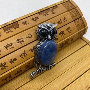 Colgante de búho con piedra azul y metal plateado retro sobre pergamino de bambú