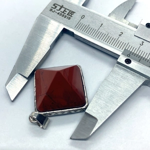 Vue détaillée d'un pendentif pyramide en jaspe rouge de 25mm mesuré au pied à coulisse