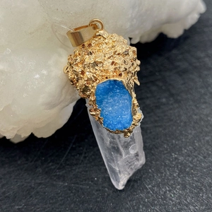 Détail macro du pendentif en cristal naturel avec pierre druzy bleue et dorure texturée