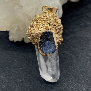 Vue détaillée d'un pendentif en cristal naturel avec capuchon doré et pierre bleue
