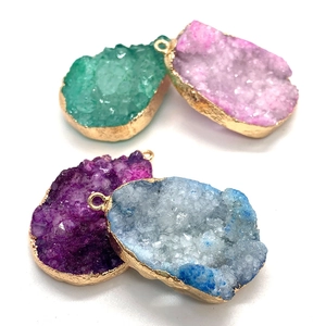 Détail de pendentifs en pierre naturelle druzy avec bords dorés et texture cristalline