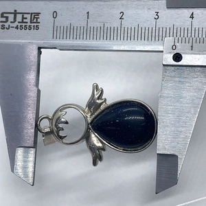 Misura della larghezza di 35mm del ciondolo angelo in pietra blu con un calibro digitale