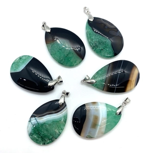 Detailed view of six teardrop agate pendants with natural green and black banded textures