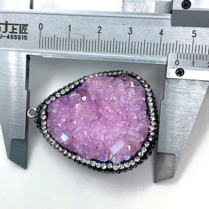 Gros plan d'un pendentif goutte en druzy violet mesuré à 3,7 cm avec un pied à coulisse