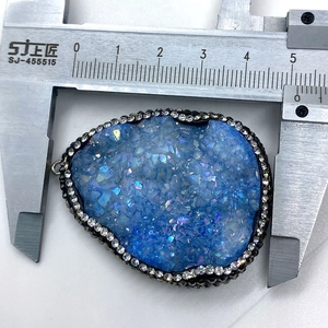 Vue macro mesurant la largeur d'un pendentif en cristal bleu avec un pied à coulisse précis