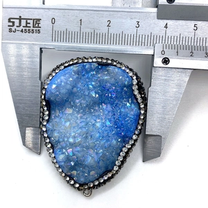 Pendentif goutte en druzy bleu avec bordure en strass mesuré au pied à coulisse