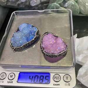 Détail de pendentifs druzy en forme de goutte avec bordure en strass sur une balance