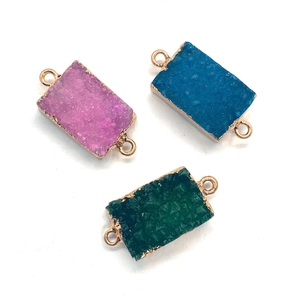 Makro-Detail von rechteckigen Druzy-Stein-Anhängern mit Goldrand für DIY-Schmuck