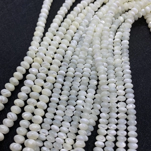 Détail macro de perles en nacre naturelle polie avec éclat iridescent pour création bijoux