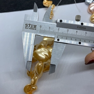Macro shot measuring a 15mm golden baroque irregular pearl with a digital caliper