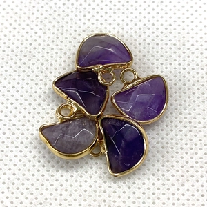 Macro detail of five faceted purple amethyst pendants with elegant gold plated metal borders