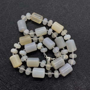 Macro detail of cylinder and flat natural stone beads with polished grey and yellow textures