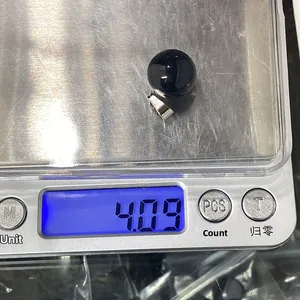 Macro shot showing a black obsidian round stone pendant weighing 4.09g on a scale