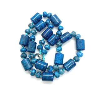 Detail of blue turquoise stones and silver lobster clasp on a woven beaded necklace