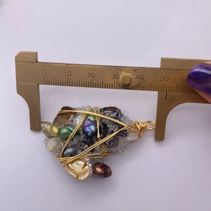 Macro che mostra la misura di 45 mm del ciondolo di perle a filo avvolto irregolare