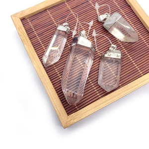 Pendentifs en quartz blanc naturel en forme de prisme hexagonal sur plateau en bambou