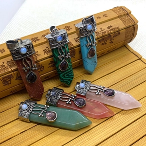 Detailed view of vintage sword-shaped gemstone pendants on a traditional bamboo mat