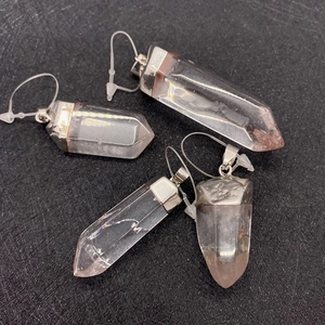 Pendentifs hexagonaux en cristal de quartz naturel avec bélières en argent sur fond noir