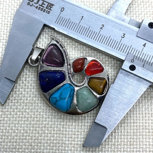 Macro view of snail-shaped pendant with seven natural stones measured by caliper