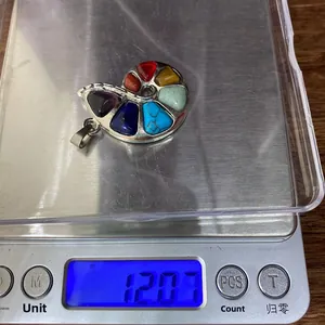 Macro detail of snail pendant weighing 12.07g on digital scale for jewelry sizing